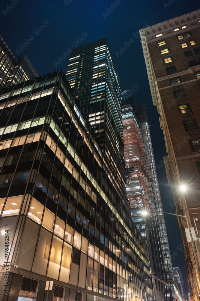 Obraz premium Illuminated Skyscrapers in a Vibrant Modern Cityscape at Night