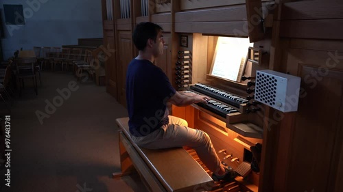 Right side view of organist playing organ in Catholic Church.