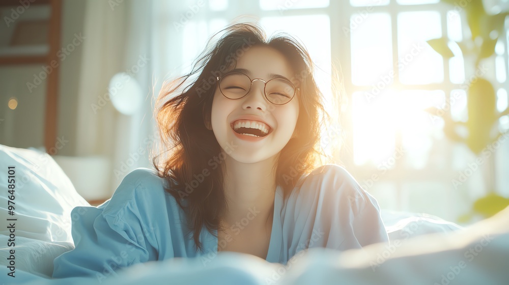 Joyful young woman in cozy bedroom, smiling cheerfully with warm sunlight streaming through a window. Joyful young woman in cozy bedroom, smiling cheerfully with warm sunlight streaming through a window.