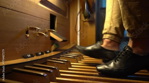 Organist's feet playing the organ pedals in a Catholic Church.