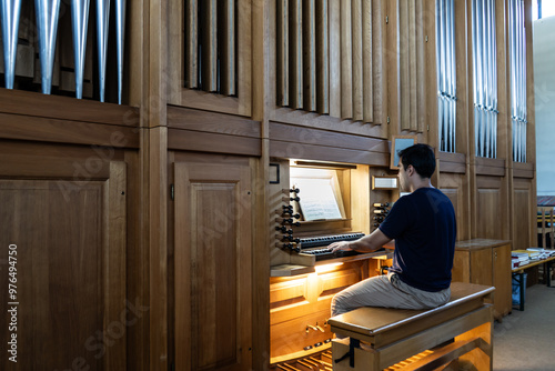 Left side view of organist playing organ in Catholic Church.