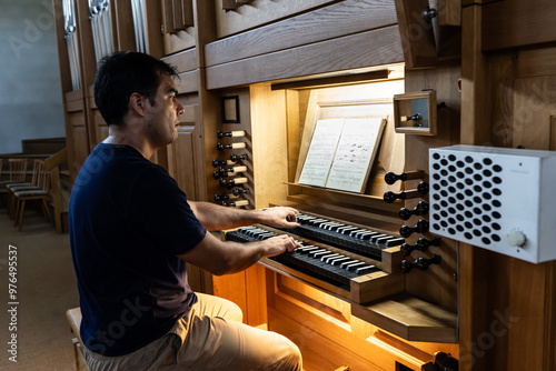 Right side view of organist playing organ in Catholic Church. photo