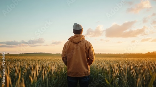 A person stands in a golden field at sunset, embodying tranquility and connection with nature.