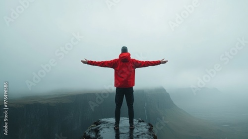 A lone traveler stands on a cliff, arms outstretched, embracing the vast, foggy landscape and the sense of freedom it brings. photo