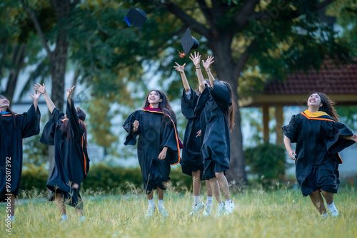 A group of women in graduation gowns are celebrating their achievements by throw