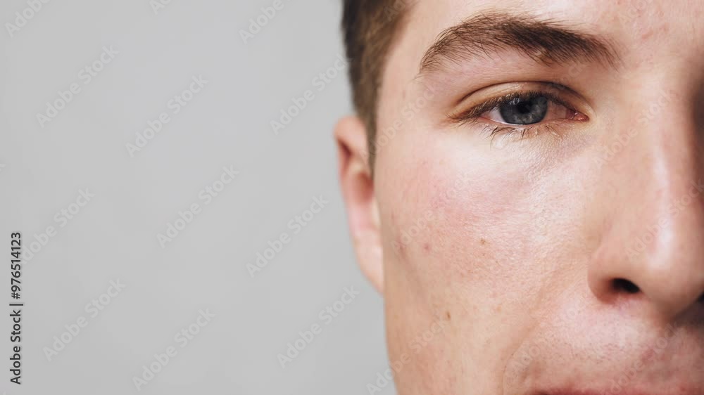 Eyewinker. Close up shot of crying guy face, man rubbing sore eye, slow motion, empty space Eyewinker. Close up shot of crying guy face, man rubbing sore eye, slow motion, empty space