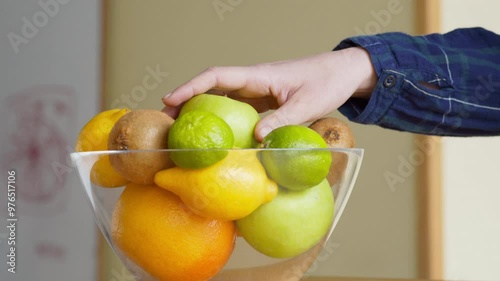Healthy snack. Young woman taking fresh apple from fruit plate at kitchen, cutting it and eating