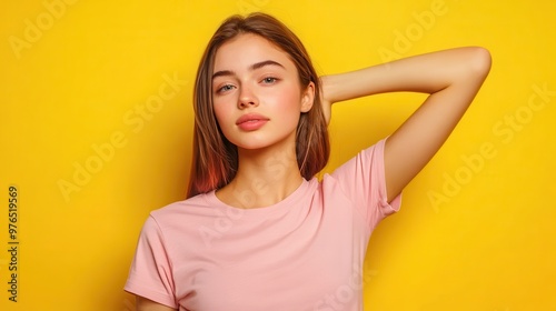 Portrait of a Beautiful Young Woman with Long Brown Hair, Wearing a Pink T-Shirt, Against a Yellow