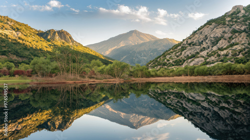 A photo of a serene landscape with a calm lake reflecting the surrounding mountains and trees. The mountains have a few rocky outcrops and are covered with greenery. There are a few trees