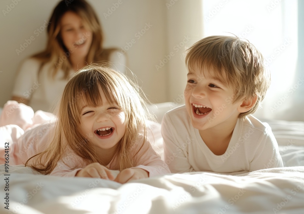 mother lying on the bed, laughing as her son plays with his sister in their bedroom during morning time together mother lying on the bed, laughing as her son plays with his sister in their bedroom during morning time together
