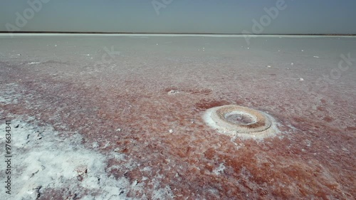 Endless salt flat landscape of Sebkha el Melah in Zarzis, Tunisia, extending to horizon with glistening salt crusts remained from evaporated water body under intense sun, creating mosaic-like pattern photo