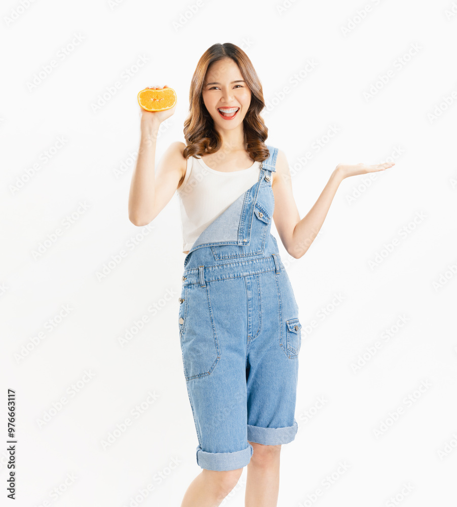 Charming joyful girl holding juicy orange on white background, vitamins for healthy skin.