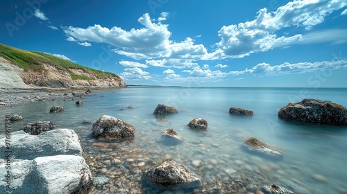 Ocean waves crashing on rocks with dramatic sky and cliffs in background