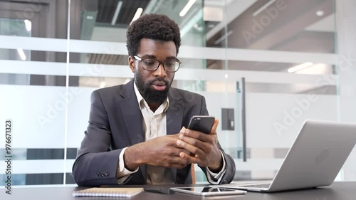Wallpaper Mural Upset african american businessman in formal suit receiving bad news on phone while sitting at a desk at a workplace in a business office. Concerned black man reads an unpleasant message on smartphone Torontodigital.ca