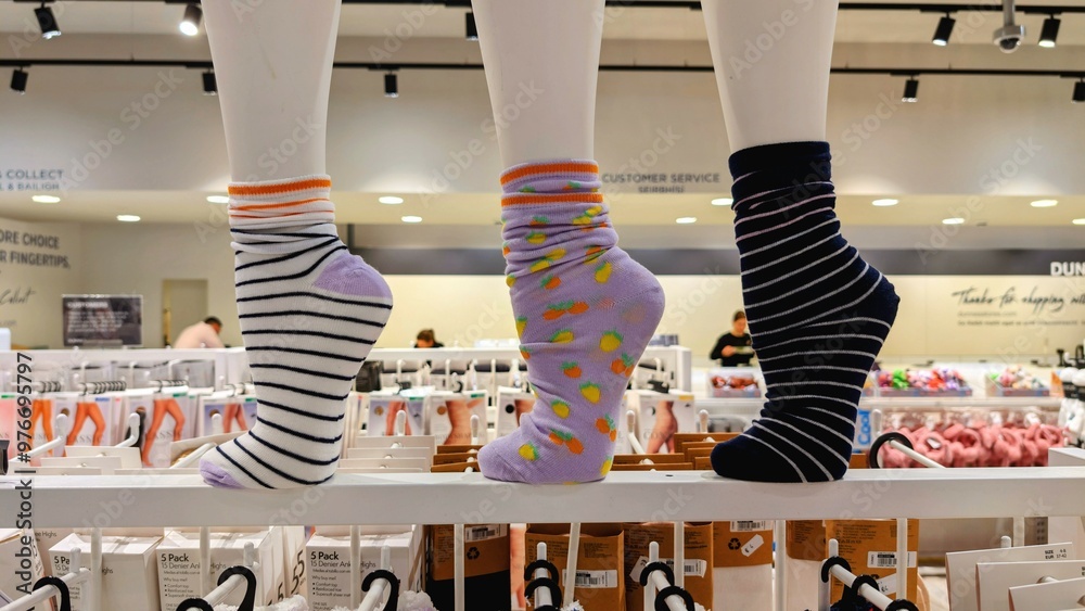 Colourful socks displayed on plastic leg in fashion store, clothing and fashion shop, background