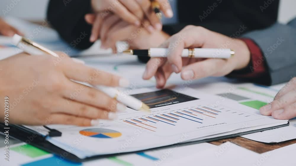 Group of business people meeting together Pointing to the graph assess business profits Group of business people meeting together Pointing to the graph assess business profits