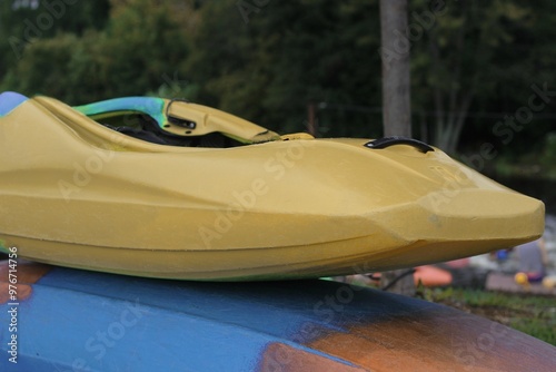 Two colorful kayaks stacked with a forest in the background photo