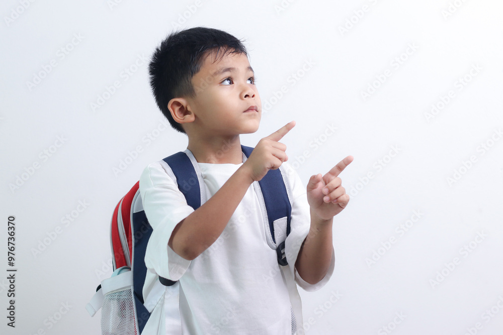 cute little boy in casual clothes with backpack on white background. cute little boy in casual clothes with backpack on white background.