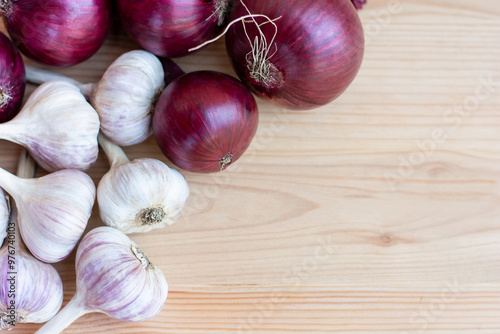 garlic and red onion lying on a wooden background, autumn harvest, copy space. High quality photo