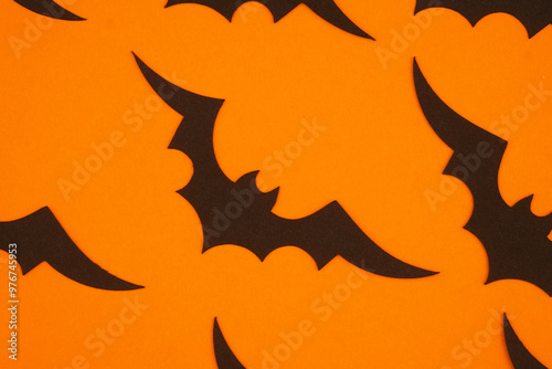 Black bats on bright orange background create a festive Halloween atmosphere for decorations