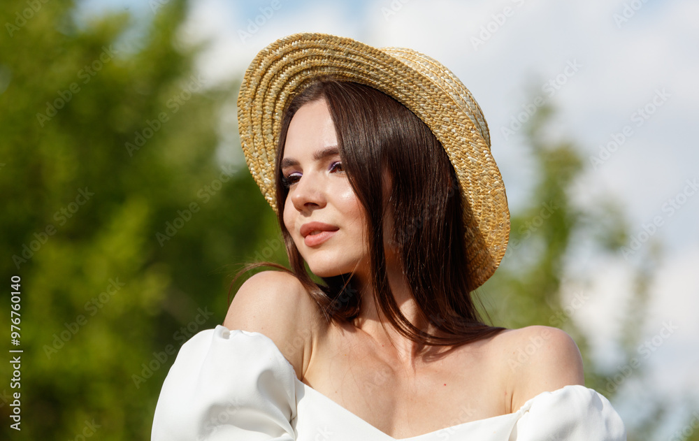 Φωτογραφία Portrait of a brunette girl in a straw hat in nature. Close-up
