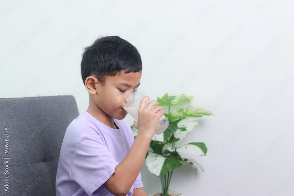Asian little cute boy drinking milk. stays home with a smiling face, feels happy, and enjoys drinking milk. Asian little cute boy drinking milk. stays home with a smiling face, feels happy, and enjoys drinking milk.