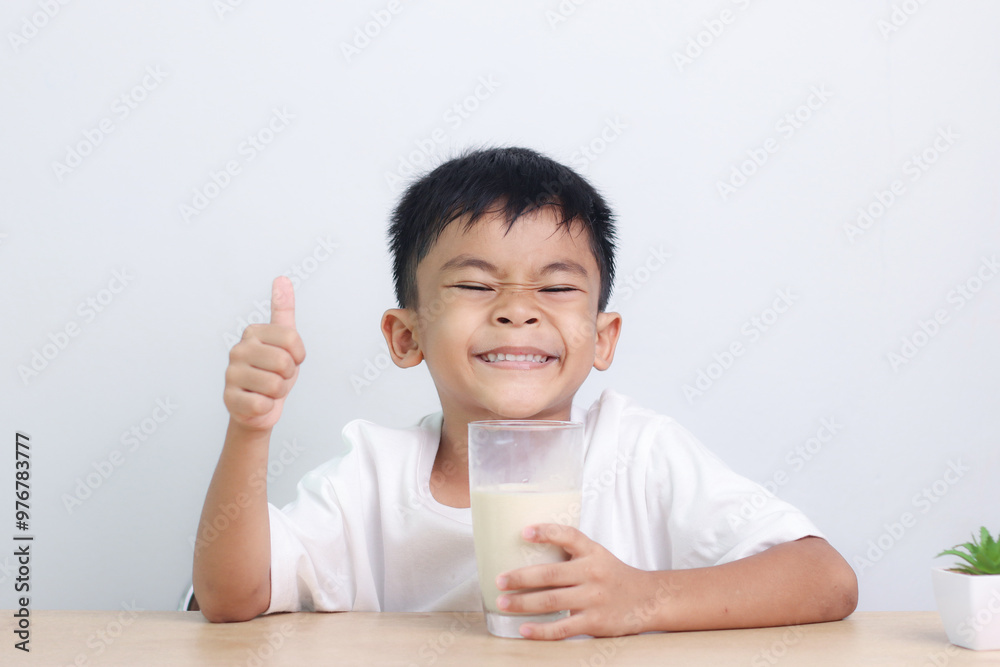 Asian little cute boy drinking milk. stays home with a smiling face, feels happy, and enjoys drinking milk. Asian little cute boy drinking milk. stays home with a smiling face, feels happy, and enjoys drinking milk.