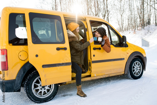 Friends arrived at cabin where they spending winter Christmas holidays. Driving car through snowy landscape.