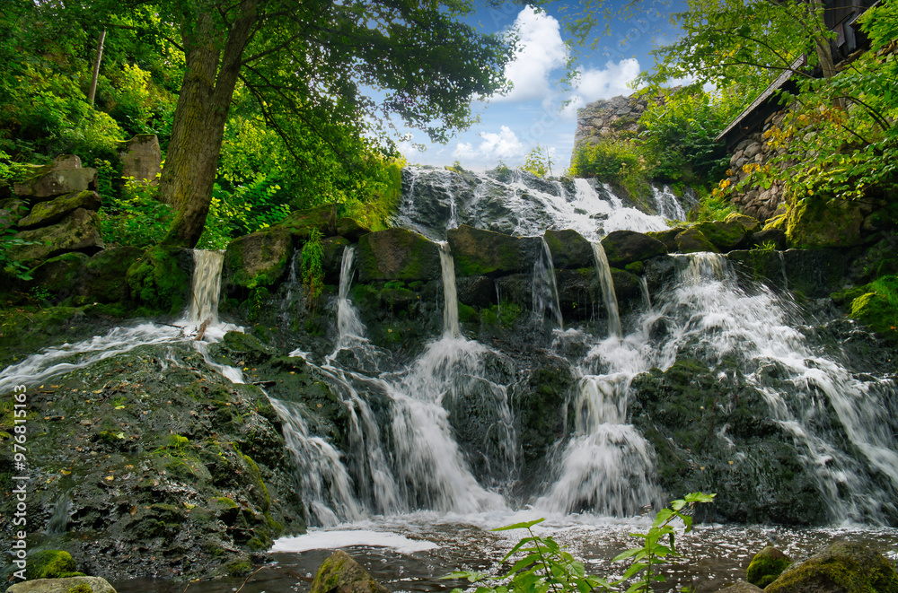 Obraz premium Small waterfall in Sweden. Moss-covered stones. Forest on the river bank. Nature