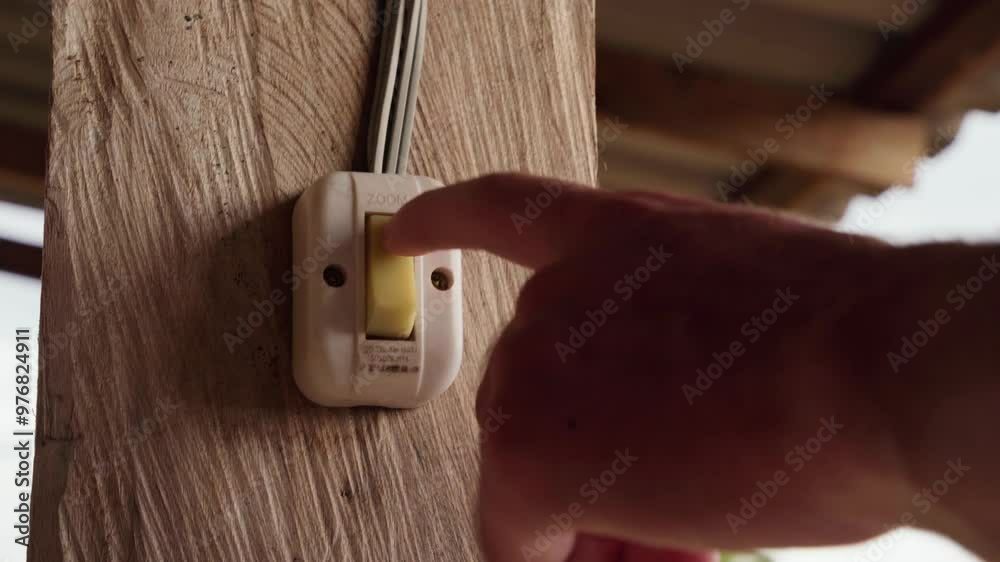 K HD cinematic close-up shot of a hand turning a white light switch on and off, mounted on a rustic wooden beam. interaction with the switch, texture of the wood and the modern white switch