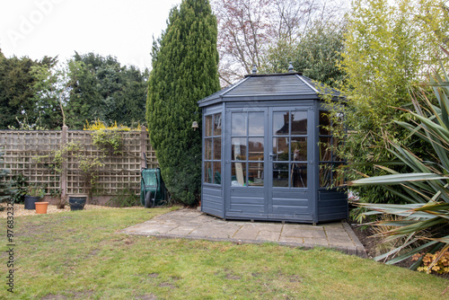 Photo of a typical British garden showing a beautiful summer house or storage shed in the UK garden photo