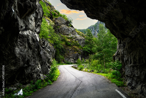 looking out of an old disused tunnel. Nature is on its way to reclaiming the road that runs through the wild Norwegian mountain landscape