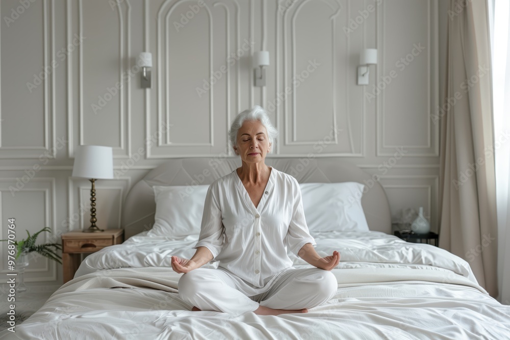 Elderly Woman Meditating Peacefully on Bed in Light-Filled Room, Embracing Calm and Tranquility Elderly Woman Meditating Peacefully on Bed in Light-Filled Room, Embracing Calm and Tranquility