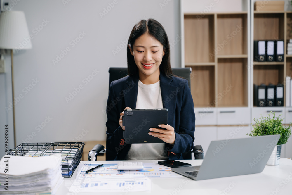 beautiful woman using laptop and tablet while sitting at her working place. beautiful woman using laptop and tablet while sitting at her working place.