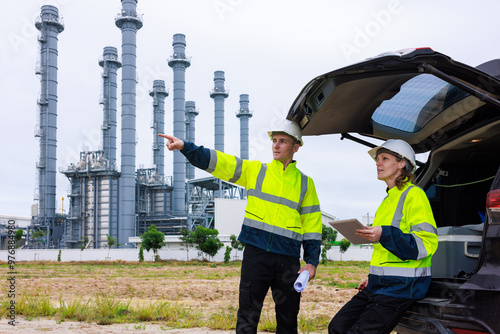 Wallpaper Mural Engineer wearing green uniform and helmet stand workplace hand holding digital tablet and blueprint, survey inspection team work plant site to work oil refinery background.. Torontodigital.ca