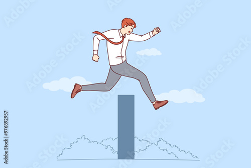Ambitious business man overcomes obstacle on path to success by jumping over high wall. Successful businessman overcomes obstacles thanks to professional experience and motivation.