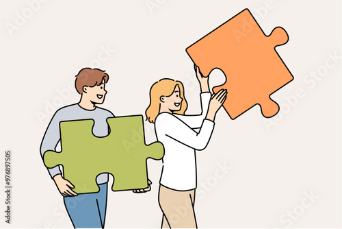 Couple of man and woman are working on building relationships, holding puzzle pieces in hands. Operating together on relationships to create strong family and avoid quarrels and disagreements