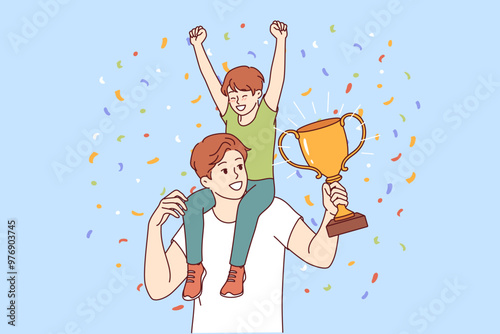Dad with champion trophy and son sitting on podium celebrates father day and is proud of having heir. Young man received award for best father of year for success in raising child.