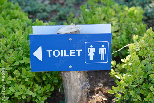 Toilet signBlue sign with white letters TOILET, arrow indicating the direction of the toilet and woman and man symbol photo