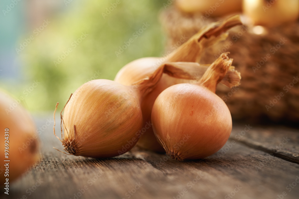 Yellow onions on a wooden table outdoors, close up Yellow onions on a wooden table outdoors, close up