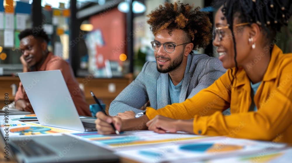 A collaborative team meeting focused on developing a successful organizational strategy, with laptops, graphs, and strategic documents on the table A collaborative team meeting focused on developing a successful organizational strategy, with laptops, graphs, and strategic documents on the table