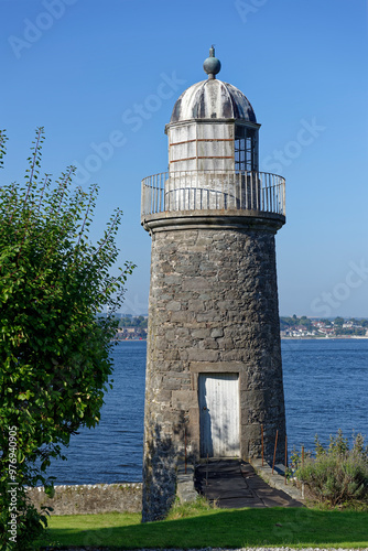 The Old East Lighthouse on the southern side of the Tay Estuary next to a private House, with a view of Broughty Ferry in the distance. photo