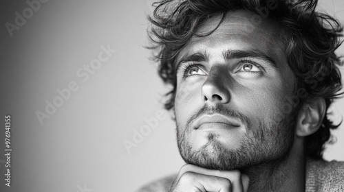 Thoughtful Gaze: A man's face, rendered in captivating black and white, reveals a moment of contemplation, his eyes gazing upwards as if lost in thought. The image exudes a sense of introspection.