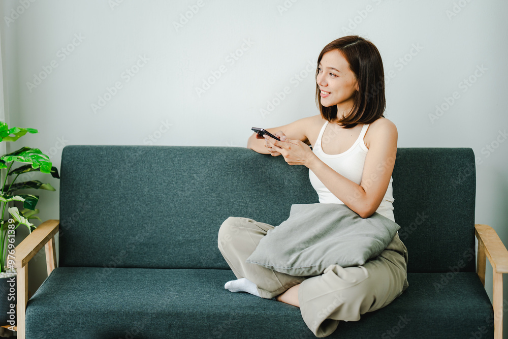 Smiling young woman uses social media to relax at home on the weekend. Relaxation concept