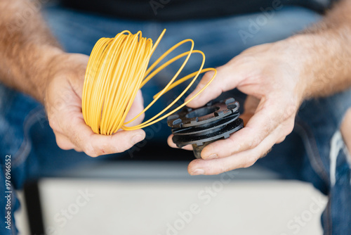 Loading plastic line into the automatic feed spool of a lawn mower - grass trimmer