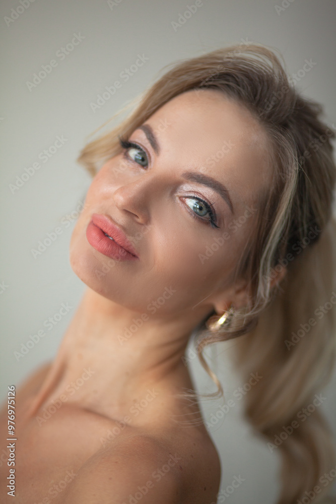 Portrait of a beautiful woman with make-up and hairstyle posing aginst the wall Portrait of a beautiful woman with make-up and hairstyle posing aginst the wall