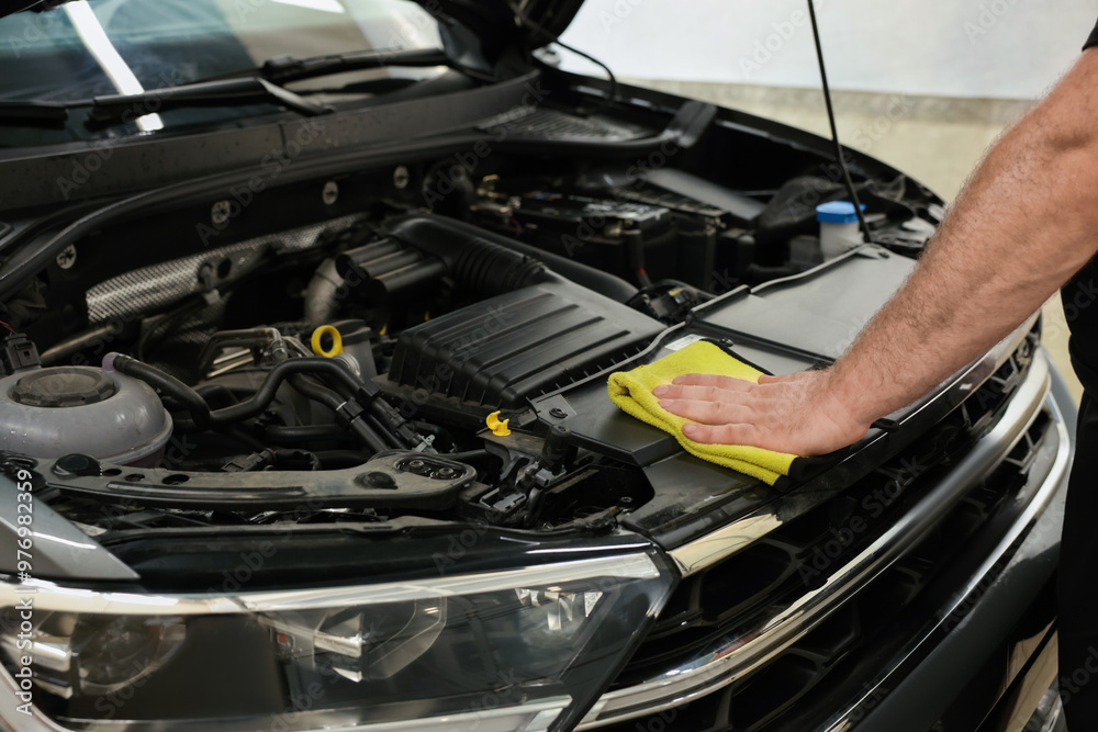 Man wiping auto engine with rag at car wash, closeup Man wiping auto engine with rag at car wash, closeup