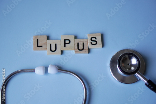 LUPUS, wooden letters with stethoscope on light blue background. medicine concepts