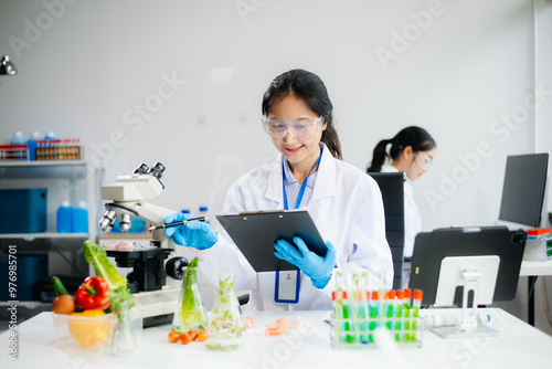 Two Asian scientists in a lab conducting food research using a microscope and lab equipment, showcasing innovation in food science