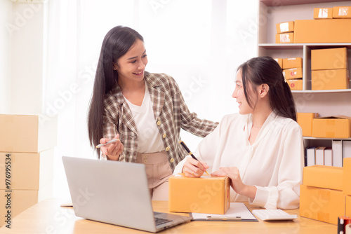 Two Asian SME business owners deliver goods Two women online store owners show happy faces. They are checking orders from customers. They deliver goods through the shipping company.